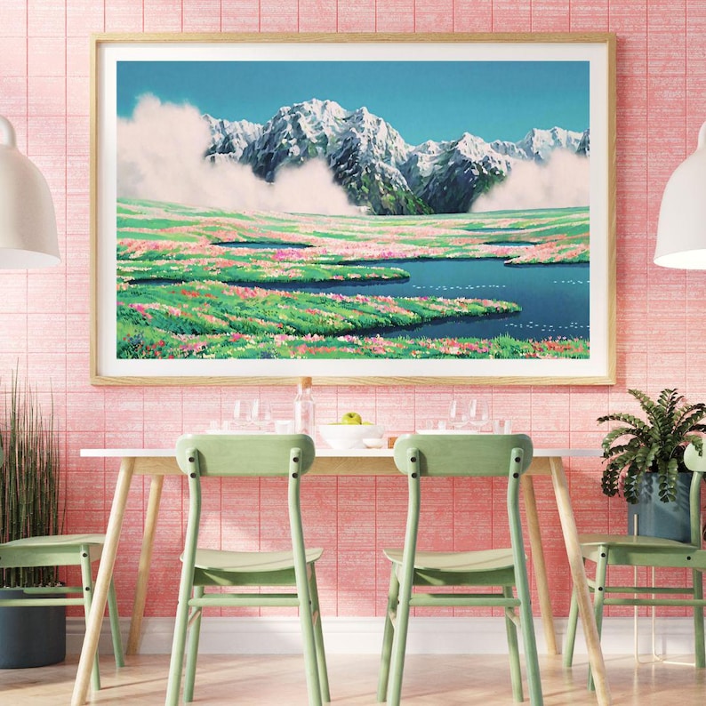 Pu&ograve; includere: Una stampa artistica incorniciata raffigura un paesaggio montano con cime innevate, un lago blu e un campo di fiori rosa e verdi. L'opera d'arte &egrave; esposta sopra un tavolo bianco con sedie verdi, contro un muro piastrellato rosa.