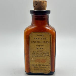 May include: An amber glass bottle with a cork stopper. The label reads "1000 TABLETS CALOMEL, 1-10 GR. (English) (PINK)" with instructions and the manufacturer's name, The S. E. Massengill Co., Bristol, Tenn.-Va.