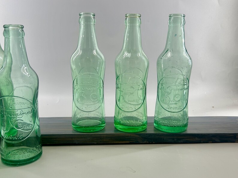 Three aqua soda bottles standing side by side against a light background.
