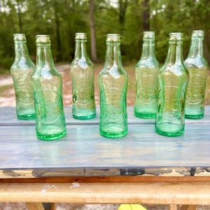 Outdoor view of all seven bottles grouped on a white display surface.