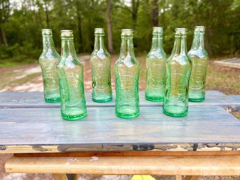 Outdoor view of all seven bottles grouped on a white display surface.