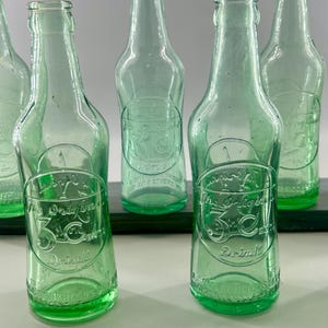 Two aqua 3 Centa bottles shown front-facing with additional bottles behind them.