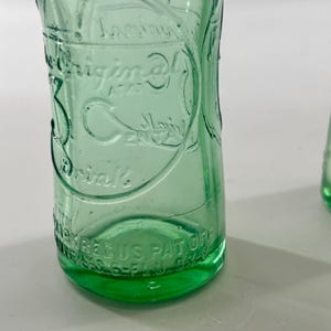 Close-up of one bottle front showing the large embossed 3 Centa design.