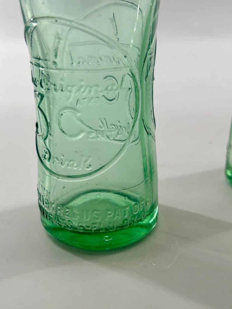 Close-up of one bottle front showing the large embossed 3 Centa design.