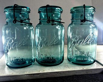 Zestaw 3 antycznych słoików Ball Ideal Aqua Blue Quart Mason Jars z drucianymi zamknięciami i szklanymi pokrywkami z 1908 roku – przedmiot kolekcjonerski z lat 20. XX wieku. Rzadki egzemplarz!