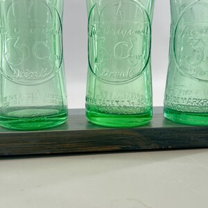 Close view of three bottle bottoms showing lower embossing and textured heels.