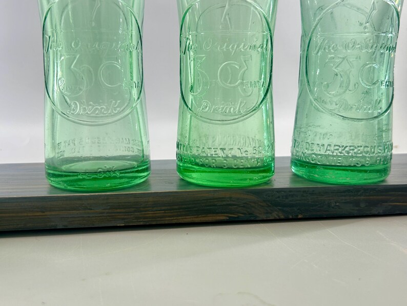 Close view of three bottle bottoms showing lower embossing and textured heels.