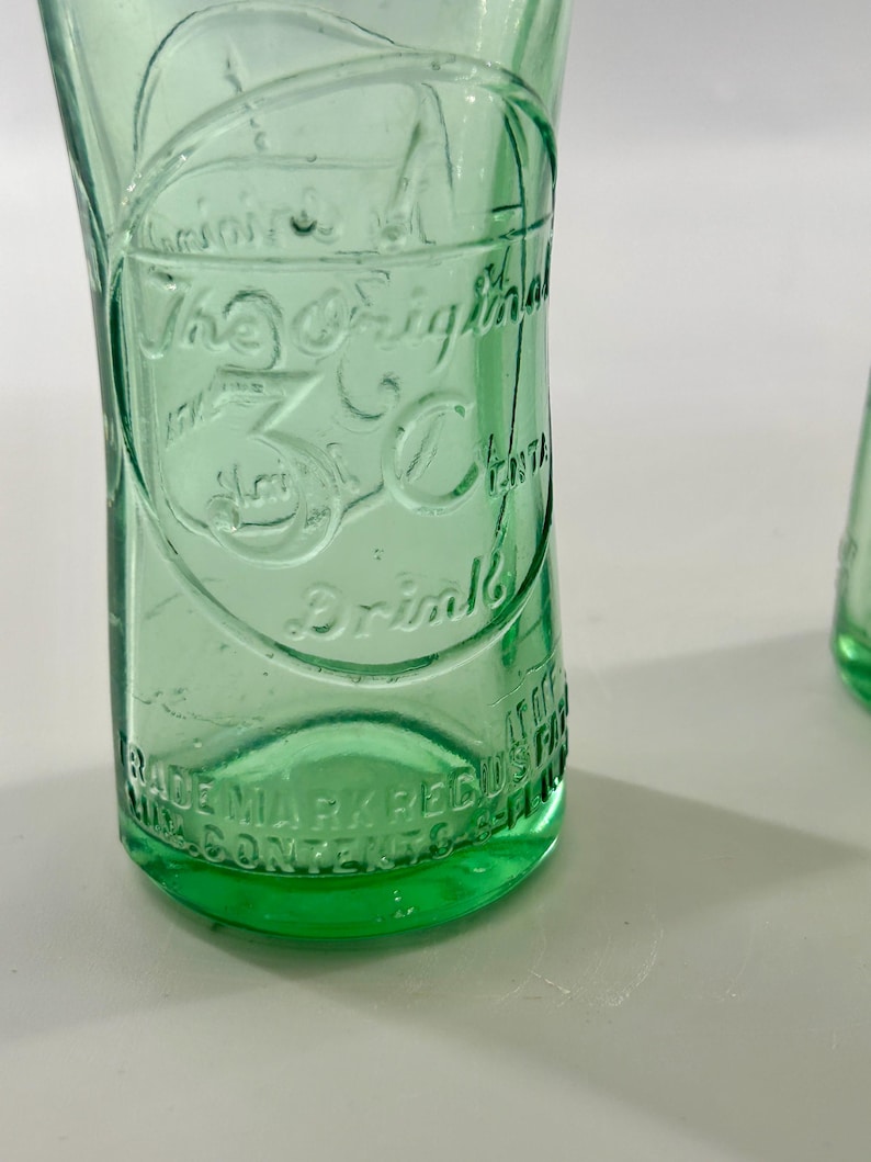 Close-up of raised 3 Centa lettering above the textured aqua glass heel.