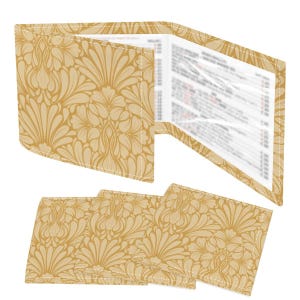 Puede incluir: Una cartera beige y tres posavasos a juego. La cartera está abierta, revelando páginas. Todos los artículos presentan un estampado floral repetido en tonos beige y crema. La cartera y los posavasos probablemente estén hechos de tela o un material similar.
