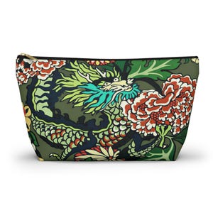Peut inclure: Une pochette zippée présentant un motif répétitif de dragon vert et bleu sarcelle entrelacé avec de grandes pivoines orange et blanches sur un fond vert olive foncé. L'accessoire possède une fermeture éclair noire sur le bord supérieur.