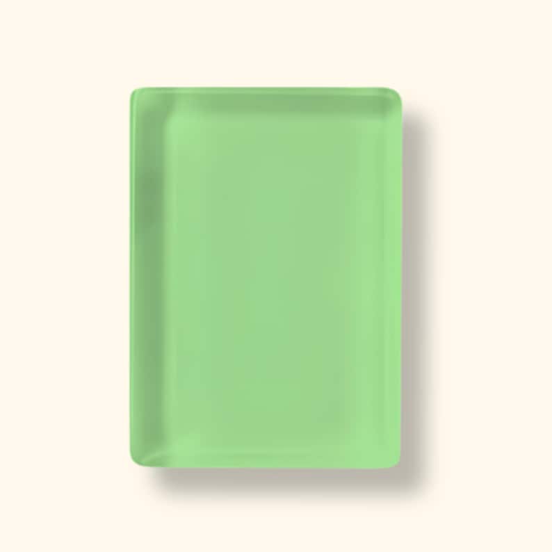 May include: A rectangular tray with rounded corners, featuring a solid light green color and a smooth, semi-translucent finish. The object has a flat surface and slightly raised edges, presenting a clean, uniform appearance without any patterns.