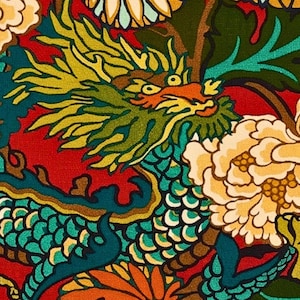 Puede incluir: Una tela textil con un patr&oacute;n repetitivo de un drag&oacute;n verde y amarillo con un dise&ntilde;o de escamas texturizadas, intercalado con grandes flores color crema y naranja sobre un fondo rojo vibrante con follaje verde oscuro.