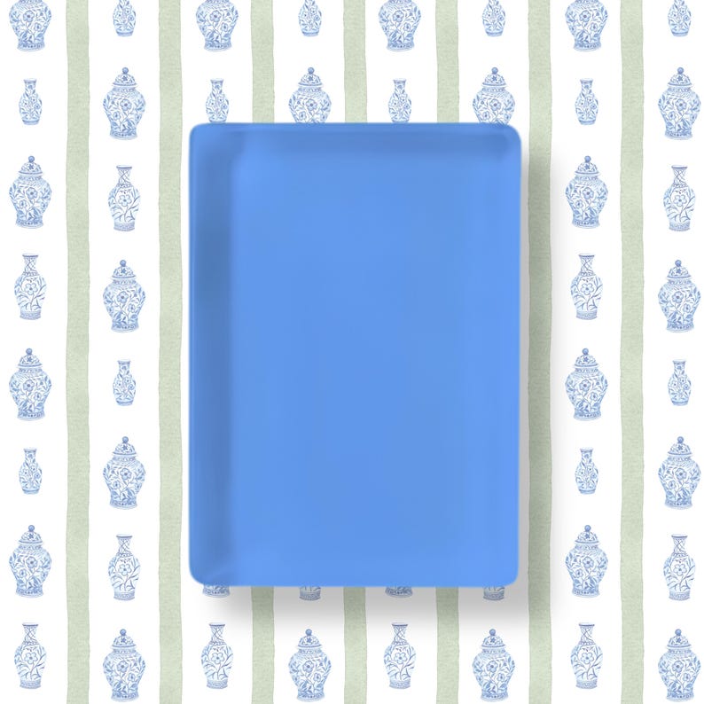 May include: A solid, rectangular, light blue tray with smooth, rounded corners and a flat surface. The tray is positioned centrally, featuring a uniform matte finish across its entire top face, providing a clean and simple aesthetic.