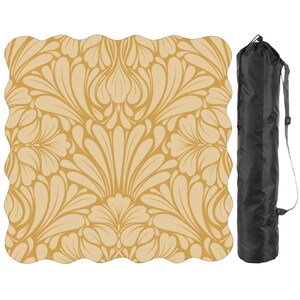 May include: A beige yoga mat with a repeating floral pattern and a black carrying bag. The mat has a scalloped edge and a symmetrical design in shades of beige and cream.