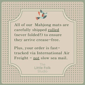 May include: A square informational graphic with a beige center and a patterned border. At the top, a stylized bird illustration in blue, red, and white. The text reads: All of our Mahjong mats are carefully shipped rolled (never folded!) to ensure they arrive crease-free. Plus, your order is fast-tracked via International Air Freight - not slow sea mail. The Little Folk Studio.