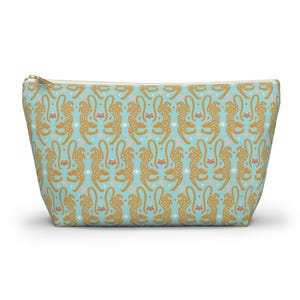 Peut inclure: Une trousse de maquillage bleu clair avec un motif répété de guépards dorés, de fleurs roses et d'étoiles blanches. Le sac a une fermeture éclair dorée et une forme rectangulaire.