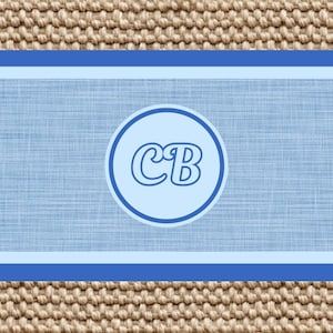 K&ouml;nnte beinhalten: Ein rechteckiges Grafikdesign mit einem hellblauen Mittelfeld in Leinenoptik, das von dunkelblauen und hellblauen horizontalen R&auml;ndern umgeben ist. Ein kreisf&ouml;rmiges Emblem in der Mitte enth&auml;lt die fetten, dunkelblauen Gro&szlig;buchstaben CB.