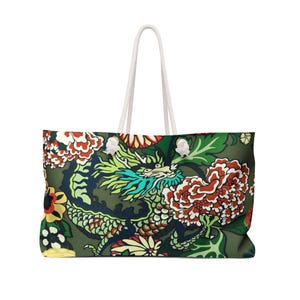 Peut inclure: Un sac fourre-tout arborant un motif répétitif de dragon vert à crinière sarcelle, entouré de grandes fleurs rouges, blanches et jaunes sur un fond vert olive. Le sac possède deux anses en corde blanche fixées par des œillets en métal argenté.