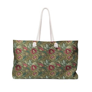 Peut inclure: Grand sac fourre-tout avec un motif floral dans les tons de vert, rouge et or. Il est doté de poignées en corde blanche et d'une forme rectangulaire. Le motif floral est détaillé et recouvre toute la surface du sac.