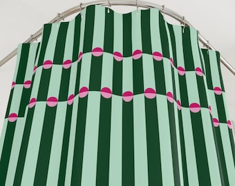 以下が含まれることがあります： 濃い緑色のストライプと薄い緑色のストライプが交互に並んだ、繰り返しのパターンが特徴のシャワーカーテン。ピンク色の半円がカーテン全体に均等に配置されています。カーテンは湾曲した金属製のロッドから吊り下げられています。