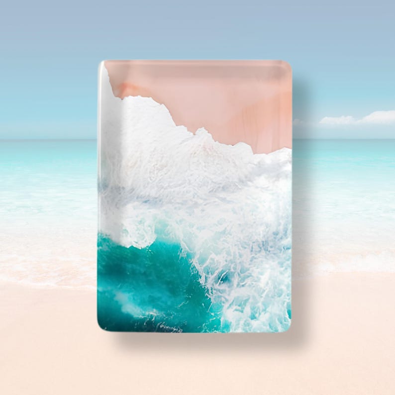 May include: A rectangular glass tray featuring a high-resolution aerial photograph of a beach scene. The design displays a soft peach-colored sandy shore meeting vibrant turquoise ocean water with white crashing waves in the center.
