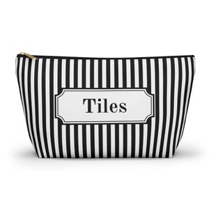 Bolsa para guardar fichas de mahjong con estampado de rayas blancas y negras y texto impreso.