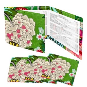 May include: A floral-patterned wallet and matching coasters. The wallet is open, revealing a menu. The design features large white flowers with pink accents on a green background. The coasters have the same design.