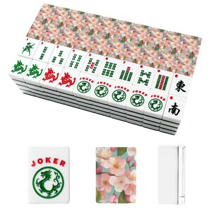 May include: A complete Mahjong set with white tiles featuring green and red dragon symbols, numbers, and Chinese characters. The set includes floral-patterned tile racks and a "Joker" tile. The tiles are stacked, ready for play.