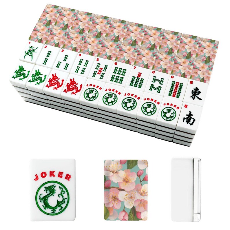 May include: A complete Mahjong set with white tiles featuring green and red dragon symbols, numbers, and Chinese characters. The set includes floral-patterned tile racks and a "Joker" tile. The tiles are stacked, ready for play.