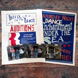 May include: Two vintage posters and several photographs are displayed on a wooden surface. The posters advertise a "Battle of the Bands Auditions" and a "Saturday Night Dance: Enchantment Under the Sea." The photographs appear to be of a band.