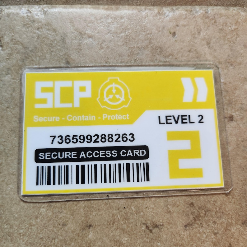 May include: A yellow and white Secure Access Card with the text "SCP" and "Secure - Contain - Protect". The card also displays "LEVEL 2", a barcode, and a long numerical sequence.