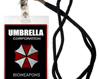Könnte beinhalten: Ein schwarz-weißer Ausweis mit dem Text "Umbrella Corporation" und "Bioweapons Division". Die Karte zeigt ein rotes und weißes Regenschirmlogo und einen silbernen Chip.