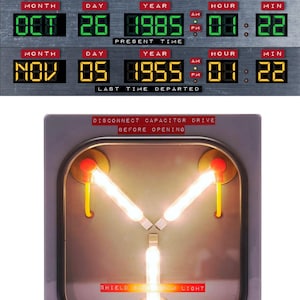 May include: A close-up of a time machine from the movie Back to the Future. The time machine has a digital display showing the date and time. The display shows the date as October 26, 1985, and the time as 07:22 PM. The display also shows the date as November 5, 1955, and the time as 01:22 PM. The time machine also has a warning sign that says "Disconnect capacitor drive before opening."