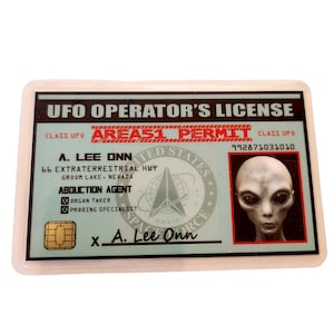 Op de afbeelding: Een novelty UFO Operator's License met een transparante plastic overlay. De licentie bevat de tekst "UFO OPERATOR'S LICENSE", "AREA 51 PERMIT" en een foto van een alien. De naam "A. Lee Onn" staat op de licentie.