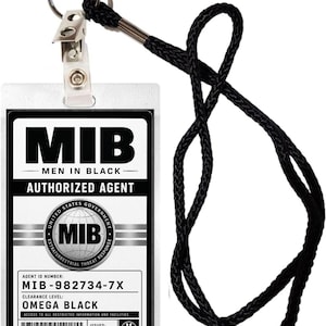 Puede incluir: Una tarjeta de identificación rectangular de agente autorizado de Men in Black en un soporte de plástico transparente con un cordón negro. La tarjeta muestra el logo de MIB, el número de agente MIB-982734-7X, nivel Omega Black y fecha 6/2/2026.