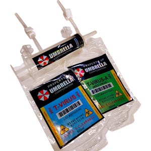 May include: A clear syringe and two pouches with labels. The syringe has the text "UMBRELLA CORPORATION". The pouches are labeled "T-VIRUS" and "T-VIRUS-A (ANTI-VIRUS)" with the Umbrella Corporation logo and warnings. The pouches are filled with a clear liquid.