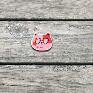 autocollant de fierté de chat arc-en-ciel de Zazzle.be Liste d'envies Vous avez des idées ? Sticker en vinyle Kitty LGBTQ+ mignon | Lunettes de soleil coeur Pride Cat | Sticker étrange kawaii | Cadeau du Mois de la fierté