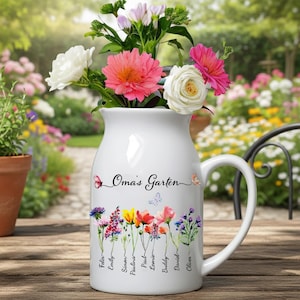 May include: White ceramic jug with a handle, filled with colourful flowers. The jug has the text "Oma's Garten" and names of people below a floral design. The flowers include pink, white, and purple blooms.