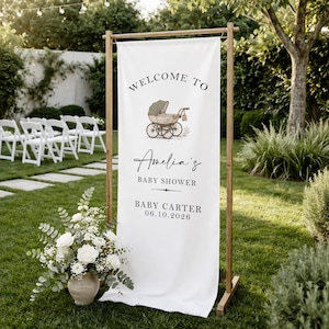 May include: A white banner with the words "WELCOME TO" and "Amelia's BABY SHOWER" in black script. A vintage baby carriage illustration is above the text. The date "06.10.2026" is printed below the name "Baby Carter".
