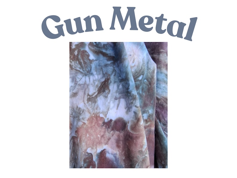 May include: A piece of fabric featuring a tie-dye pattern with blended shades of brown, blue, and white. The text "Gun Metal" is printed in a grey, curved font above the fabric, which displays a marbled, organic appearance with soft color transitions.