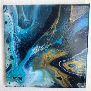 Könnte beinhalten: Abstrakte Acrylmalerei auf Leinwand mit einem Fluid-Art-Design. Das Kunstwerk zeigt eine Mischung aus Blau-, Türkis-, Gold- und Weißtönen, die eine dynamische und strukturierte Komposition erzeugt. Die Farben wirbeln und vermischen sich und erzeugen ein Gefühl von Tiefe und Bewegung.