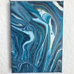 Könnte beinhalten: Abstrakte Malerei auf Leinwand mit einem fließenden, wirbelnden Design. Das Kunstwerk zeigt Farbtöne von Blau, Türkis, Weiß und Gold. Die Farbe ist geschichtet, um einen strukturierten Effekt zu erzeugen, mit sichtbaren Pinselstrichen und einem glänzenden Finish.