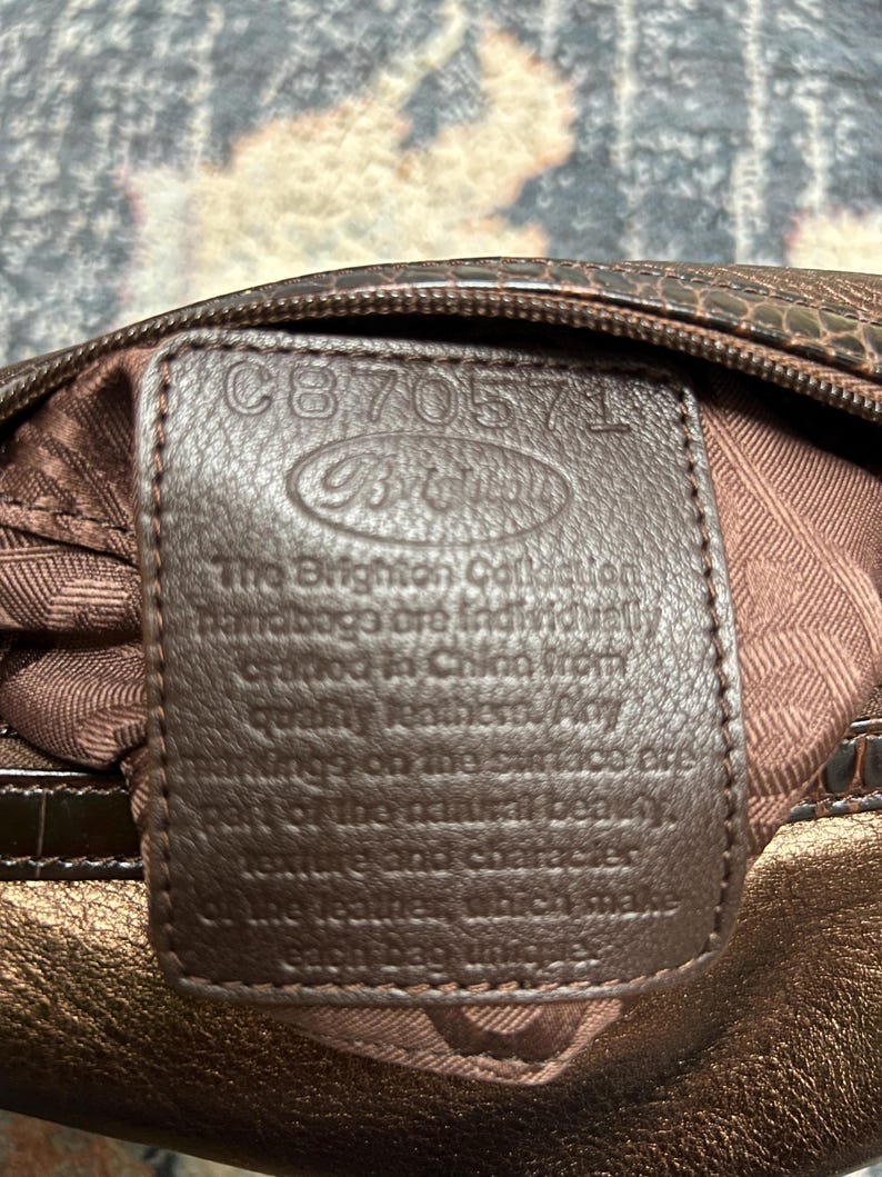 May include: A rustic wooden sign with the text "Welcome" in a handwritten style. The sign is painted white with a distressed finish, and features a decorative floral design in the corner. The background is a blurred image of a wooden surface.