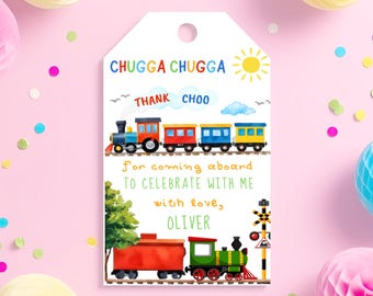 May include: A white gift tag with a colorful train illustration. The tag reads "CHUGGA CHUGGA THANK CHOO" and "For coming aboard to celebrate with me with love, OLIVER". The tag has a hole at the top for hanging.