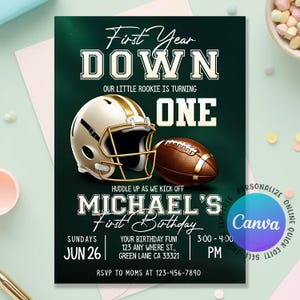 Puede incluir: Una invitación verde oscuro con temática de fútbol. El texto dice "First Year Down" y "Michael's First Birthday". Se muestra un casco de fútbol y un balón de fútbol. La fecha es el 26 de junio.