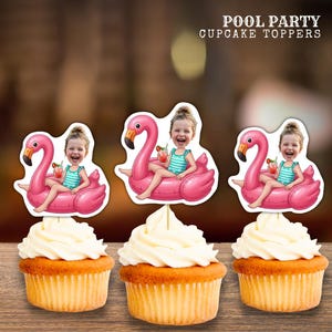 Op de afbeelding: Drie cupcakes met witte glazuur en flamingo-thema cupcake toppers. Elke topper toont een cartoonafbeelding van een persoon op een roze flamingo-drijver met een drankje. De tekst "POOL PARTY CUPCAKE TOPPERS" staat bovenaan.