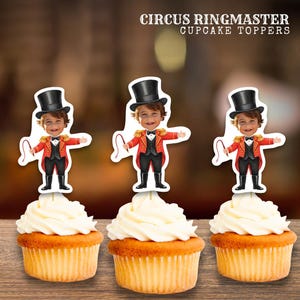 May include: Three cupcakes with circus ringmaster cupcake toppers. Each topper depicts a cartoon ringmaster in a red jacket, black top hat, and holding a whip. The cupcakes have a swirl of white icing and a golden-brown sponge base. Text at the top reads "CIRCUS RINGMASTER CUPCAKE TOPPERS."