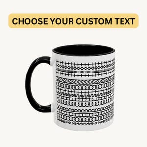 Puede incluir: Taza de cerámica blanca con interior y asa negros. La taza presenta un patrón negro repetido de varios diseños cosidos. El texto "CHOOSE YOUR CUSTOM TEXT" se muestra en una pancarta amarilla encima de la taza.