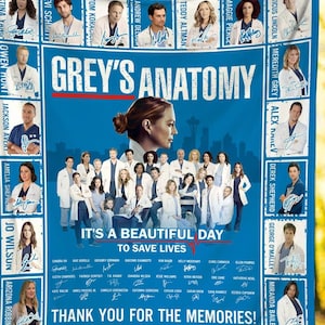 May include: A blue blanket featuring the text "Grey's Anatomy" and images of the show's cast. The blanket includes the phrase "It's a beautiful day to save lives" and "Thank you for the memories!"