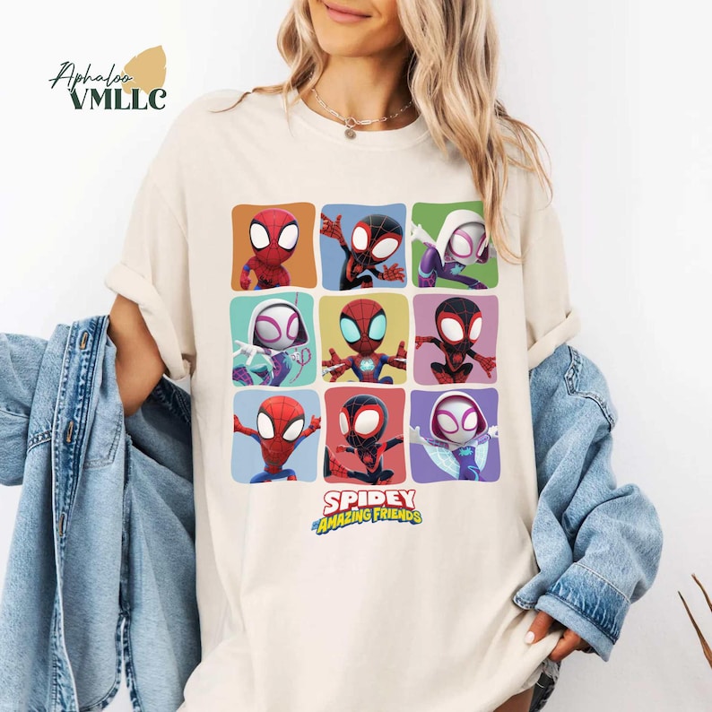 Może przedstawiać: Kremowa koszulka z siatką dziewięciu postaci z kresk&oacute;wek Spider-Mana w r&oacute;żnych pozach i kolorach. Koszulka zawiera napis "SPIDEY AND HIS AMAZING FRIENDS" w kolorze zielonym i ż&oacute;łtym.